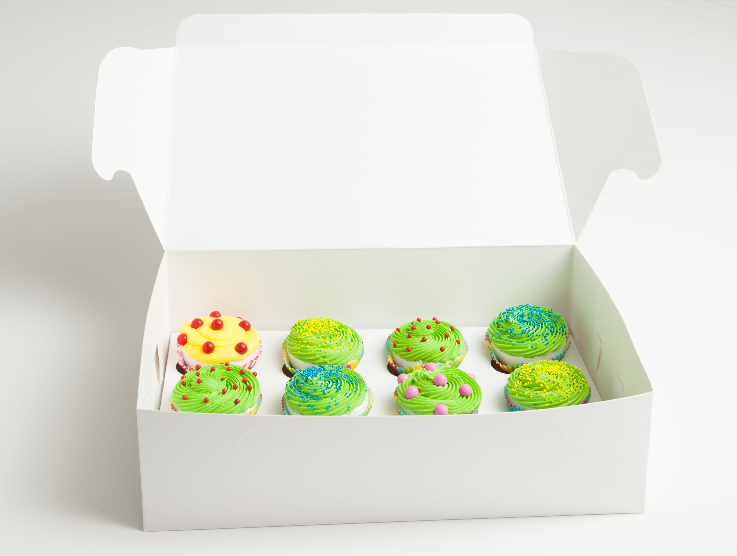 Open takaway box full of cupcakes